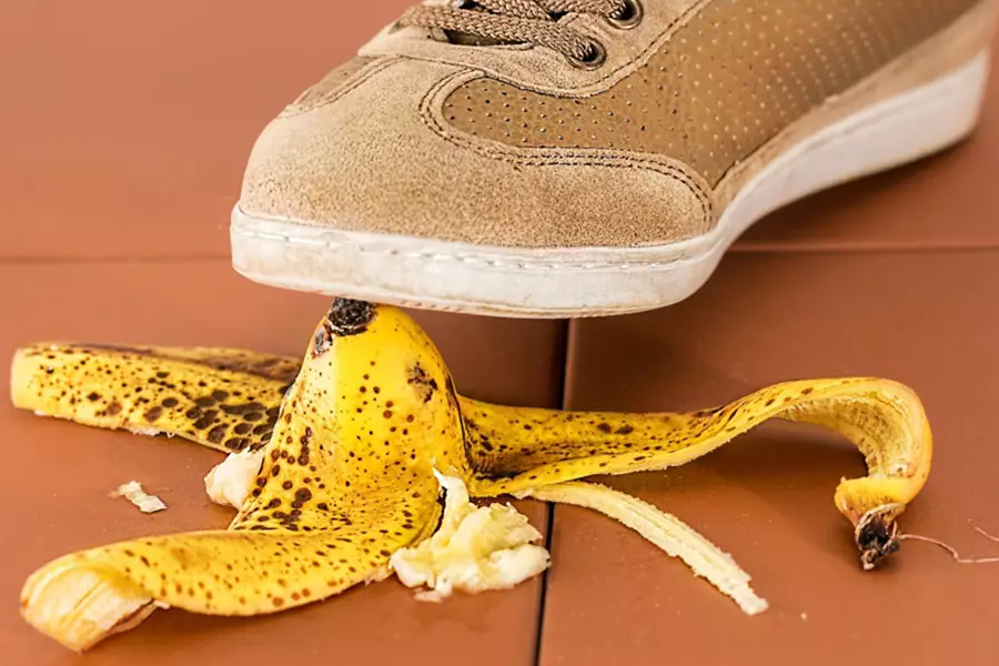 Image d'en-tête de l'article Je Réalise " Sortir de la manipulation ! ", sur laquelle l'on voit une basket en gros plan, s'apprêtant à marcher sur une peau de banane, sur fond de carrelage brun.